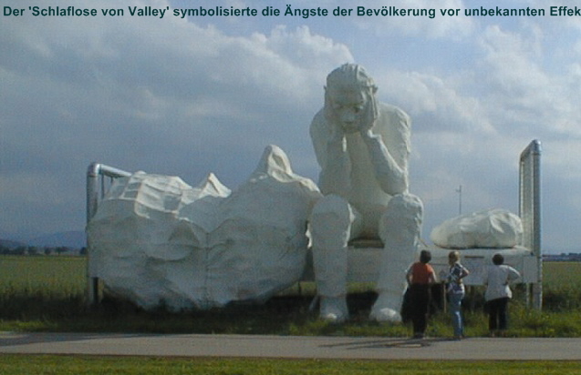 Mit der Skulptur eines Schlaflosen protesttierten Bewohner des bayerischen Ortes Valley gegen einen benachbarten US-Grosender. Der Sender, einer seiner Anennenmasten ragt hinter dem Kopfkissen des Schlaflosen hervor, ist mittlerweile abgebaut worden Foto: IZgMF