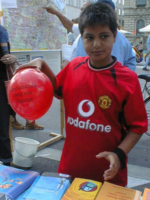 Ein junger Vodafone-Trikotrger am Stand von Mobilfunkkritikern. Szene vom Mnchener Streetlife-Festval, 2003